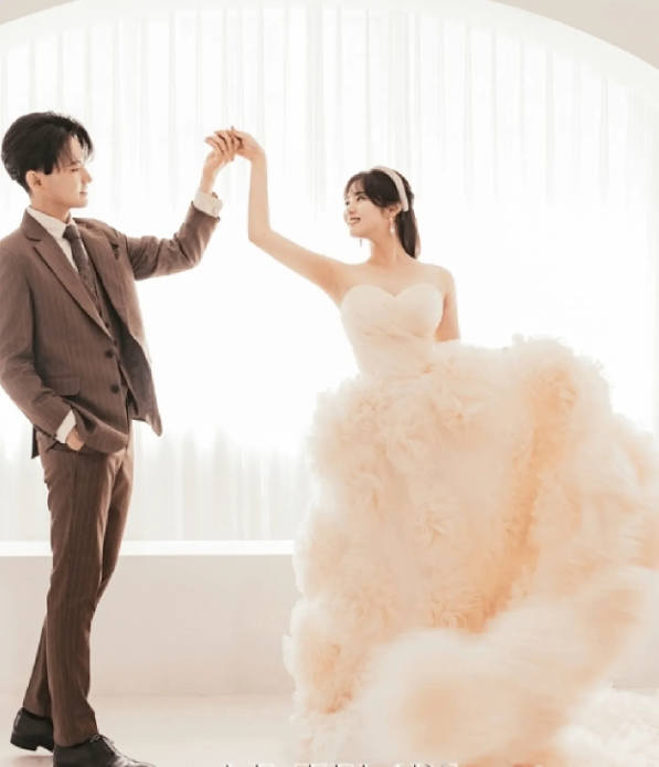 スーツを着た男性がドレスの人の手を持っている