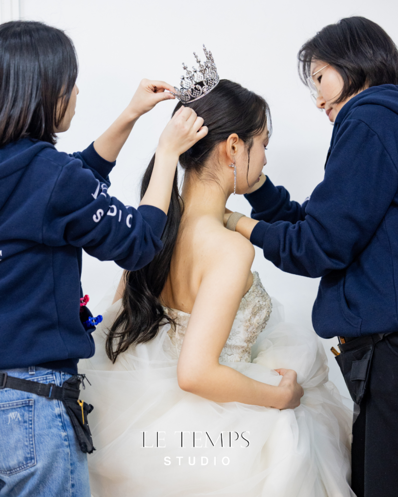 撮影中にヘアスタイルを整えてもらう花嫁